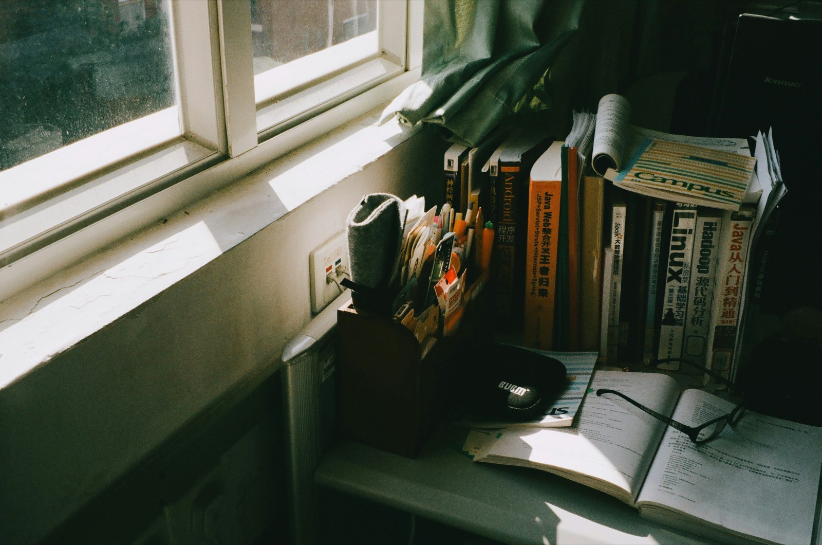 Reading glasses resting on an open book by a window